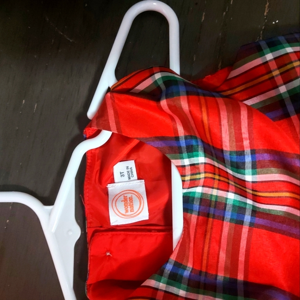 A pretty red plaid dress with a bow in the front.